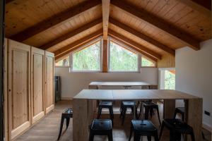 Habitación con una gran mesa de madera y sillas. en Yes we camp! Cevedale, en Ossana