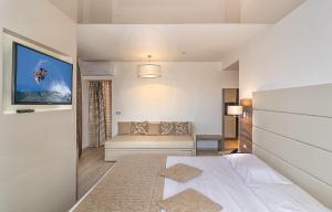 リド・ディ・カマイオーレにあるHotel Pineta Mareの白いベッドルーム(ベッド1台、ソファ付)