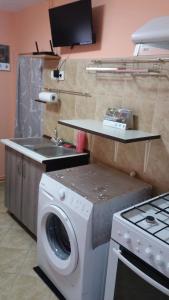 a kitchen with a washing machine and a sink at garsoniera Ștefi in Eforie Sud