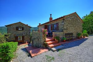 uma casa de pedra com escadas que levam a um pátio em Borgo Veronica by PosarelliVillas em Cortona