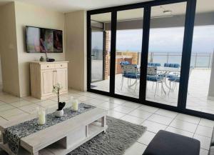a living room with a table and a balcony with a view at Hansmeyer Hill - 5 Bedroom House in Margate