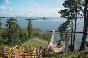 un muelle en un lago con una pequeña isla en el agua en Resort Niegocin en Wilkasy