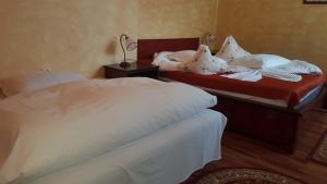 2 camas en una habitación de hotel con sábanas blancas en Complex Cabana Ciucas, en Cheia