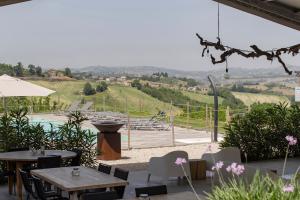 a restaurant with tables and a view of a hill at Agriturismo Unico Senso - Glamping in Montottone
