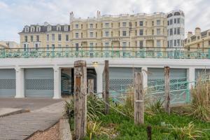 un bâtiment avec des garages et une clôture devant lui dans l'établissement Queens Hotel & Spa, à Brighton et Hove