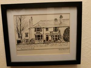 a drawing of a house in a frame on a wall at Banbury Cross B&B in Banbury