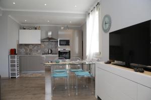 a kitchen with a table with chairs and a television at CASA AZZURRA in Imperia