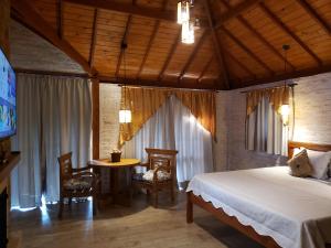 a bedroom with a bed and a table and chairs at Chalés pinha pinhão in Monte Verde
