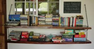 een plank vol boeken aan een muur bij Hospedaje Soma Ometepe Hotel in Moyogalpa