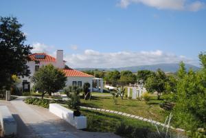 a white house with a garden in front of it at CAMBEIROS - Guest House in Alenquer