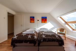 a bedroom with a bed in a attic at Vakantie aan de Maas in Broekhuizen