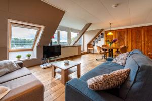 ein Wohnzimmer mit einem blauen Sofa und einem Tisch in der Unterkunft Vakantie aan de Maas in Broekhuizen