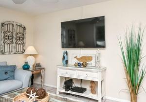 a living room with a couch and a tv on a wall at Bianco Sands in Siesta Key