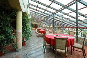 un restaurante con mesas y sillas y techo de cristal en Manor Hotel, en Olsztyn