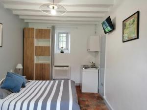 um quarto com uma cama e uma televisão na parede em La Petite Charnasserie em Angers