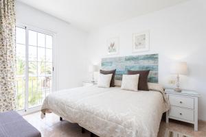 a white bedroom with a bed and a window at Vivienda Vacacional La Laguna Deluxe 5 in La Laguna