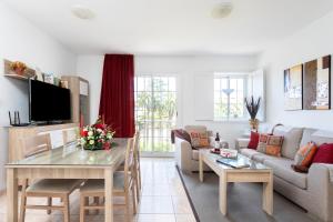 una sala de estar con una mesa y un sofá en Vivienda Vacacional La Laguna Deluxe 5, en La Laguna