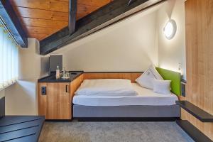 a bedroom with a large bed with a wooden headboard at Landhotel Naafs-Häuschen in Lohmar