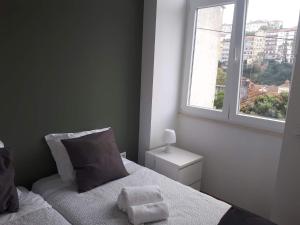 een kleine slaapkamer met een bed en een raam bij Coimbra Holiday Residence in Coimbra