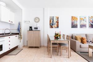 een keuken en een woonkamer met een tafel en een bank bij Vivienda Vacacional La Laguna Deluxe 6 in La Laguna