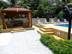 un patio con cenador y piscina en Villa Pasyon, en La Digue
