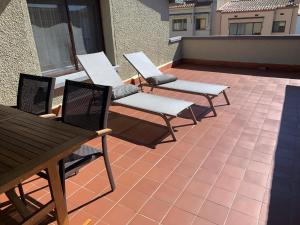 three chairs and a table on a patio at Can Municoy in Castelló d'Empúries