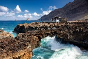 a bridge over the water on a rocky beach at Hotel Puntagrande in Frontera