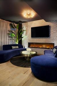 林垦The Kindler Hotel的客厅设有蓝色的沙发和壁炉