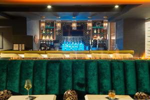 林垦The Kindler Hotel的酒吧设有白色的桌椅和绿色的墙壁