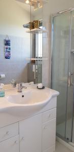 un bagno bianco con lavandino e doccia di Villa Acqua Doria a Coti-Chiavari Altre 37 foto