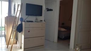 una camera da letto con un comò con una televisione sopra di Villa Acqua Doria a Coti-Chiavari