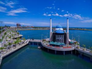 a building in the water next to a pier at Monoloog Hotel Makassar in Makassar