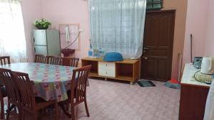 een kamer met een tafel en stoelen en een keuken bij Homestay Zahra Sri Bayu in Kampong Dalam Ru