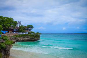 a view of a beach with a house and the ocean at Monoloog Hotel Makassar in Makassar