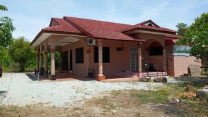 a small house with a red roof at Homestay Zahra Sri Bayu in Kampong Dalam Ru