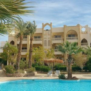 a large building with palm trees and a swimming pool at One- bedroom apartment S3 in Vip Zone Sunny Lakes in Sharm El Sheikh