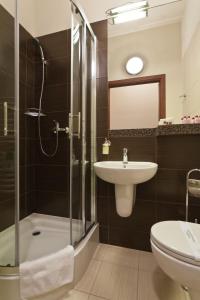 a bathroom with a shower, sink, and toilet at Hotel Maksymilian in Krakow