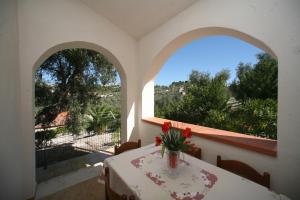 Villaggio Mare Blu في فييستي: غرفة مع طاولة مع إناء من الزهور عليها