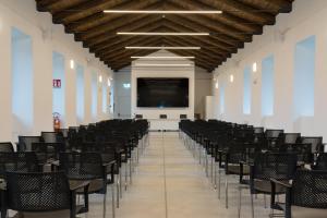 a lecture hall with chairs and a projection screen at Hotel Cascina Fossata & Residence in Turin