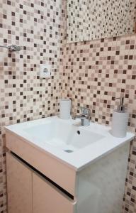 La salle de bains est pourvue d'un lavabo blanc et d'un miroir. dans l'établissement Bragas Studios, à Porto