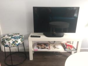 un televisor sentado en una mesa blanca con un taburete en Slapen bij Van-V, en Zierikzee