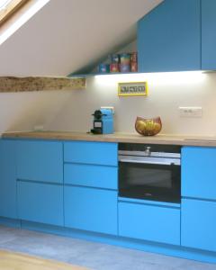 a kitchen with blue cabinets and a stove at Marais Beaubourg in Paris