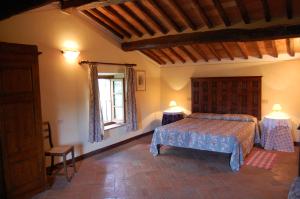 1 dormitorio con 1 cama, 1 ventana y 2 lámparas en Agriturismo Casagrande, en Montepulciano