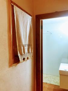 ein Vorhang hängt an einem Fenster im Bad in der Unterkunft Ca na Brila in Campos