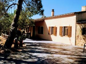 uma casa com uma árvore em frente em Ca na Brila em Campos