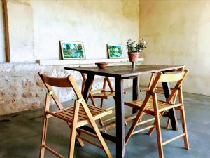 a wooden table with four chairs around it at Ca na Brila in Campos