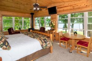 Walker的住宿－Leech Lake Resort Bed & Breakfast，卧室配有一张床和一张桌子及椅子