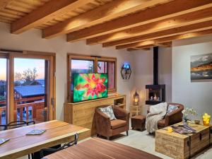 a living room with a tv and a table at Chalet Arpitan - les Carroz - Grand Massif in Les Carroz d'Araches