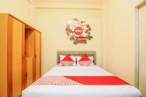 a bedroom with a bed with red and white pillows at SUPER OYO 168 K-15 Residence in Kedongdong