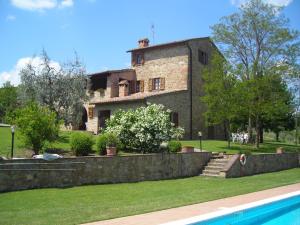 a large stone house with a pool in front of it at Agriturismo Casagrande in Montepulciano
